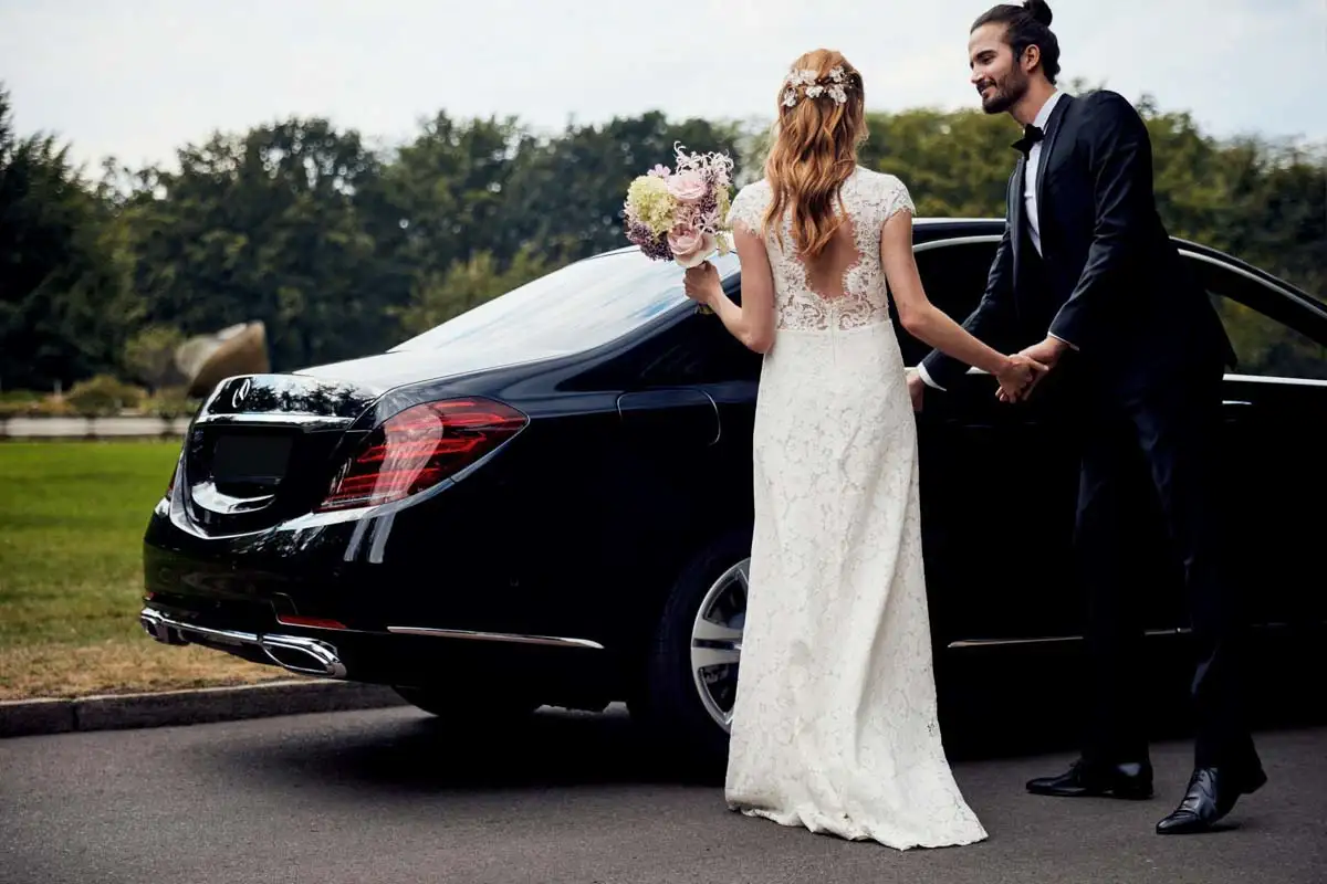 bride and groom beside a S-500 Mercedes limousine