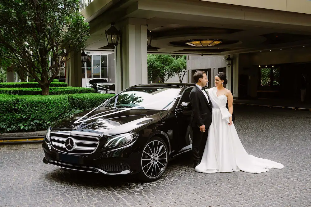bride and groom beside a luxury limo